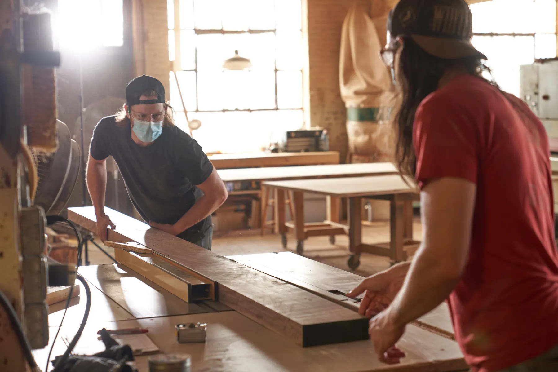 Two men sawing wood in a wood shop