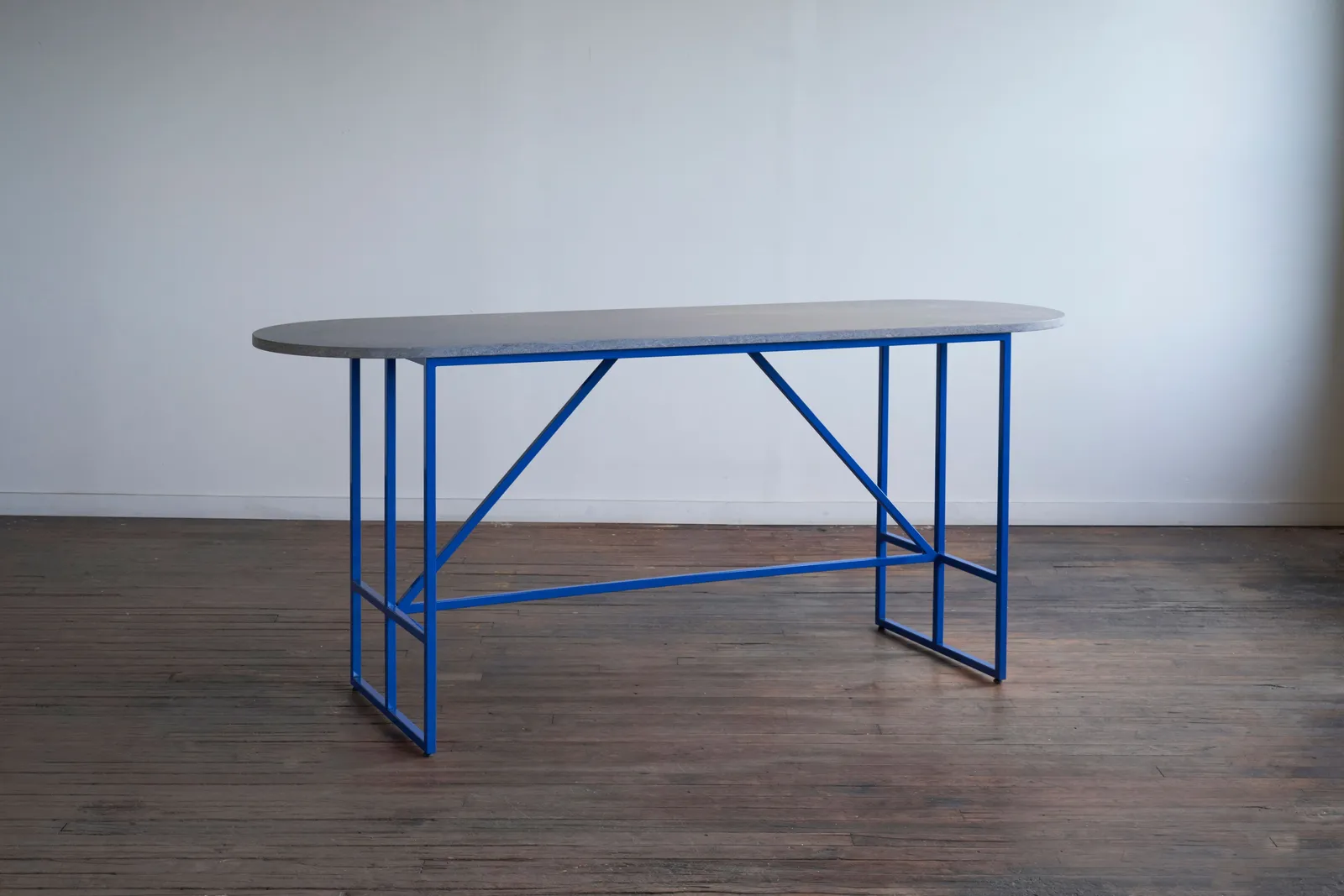 custom stone table with electric blue steel base by Icon Modern