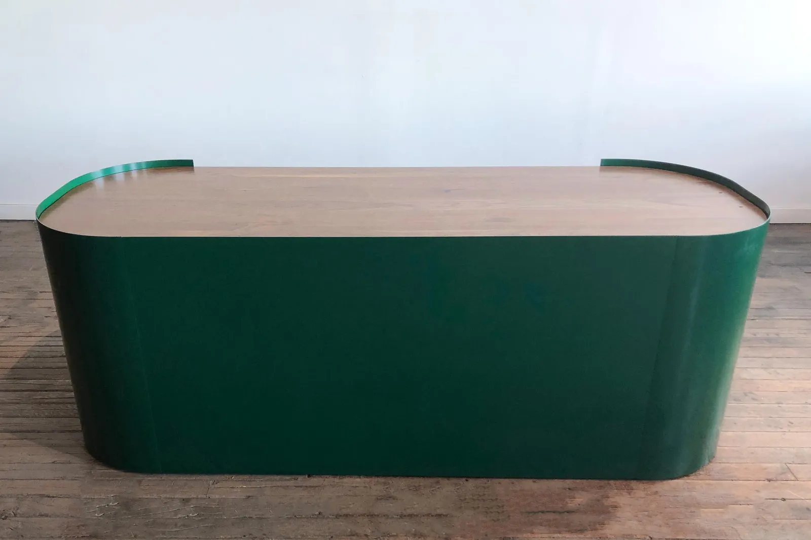 custom reception desk with powdercoated bent steel wrap and walnut top by Icon Modern