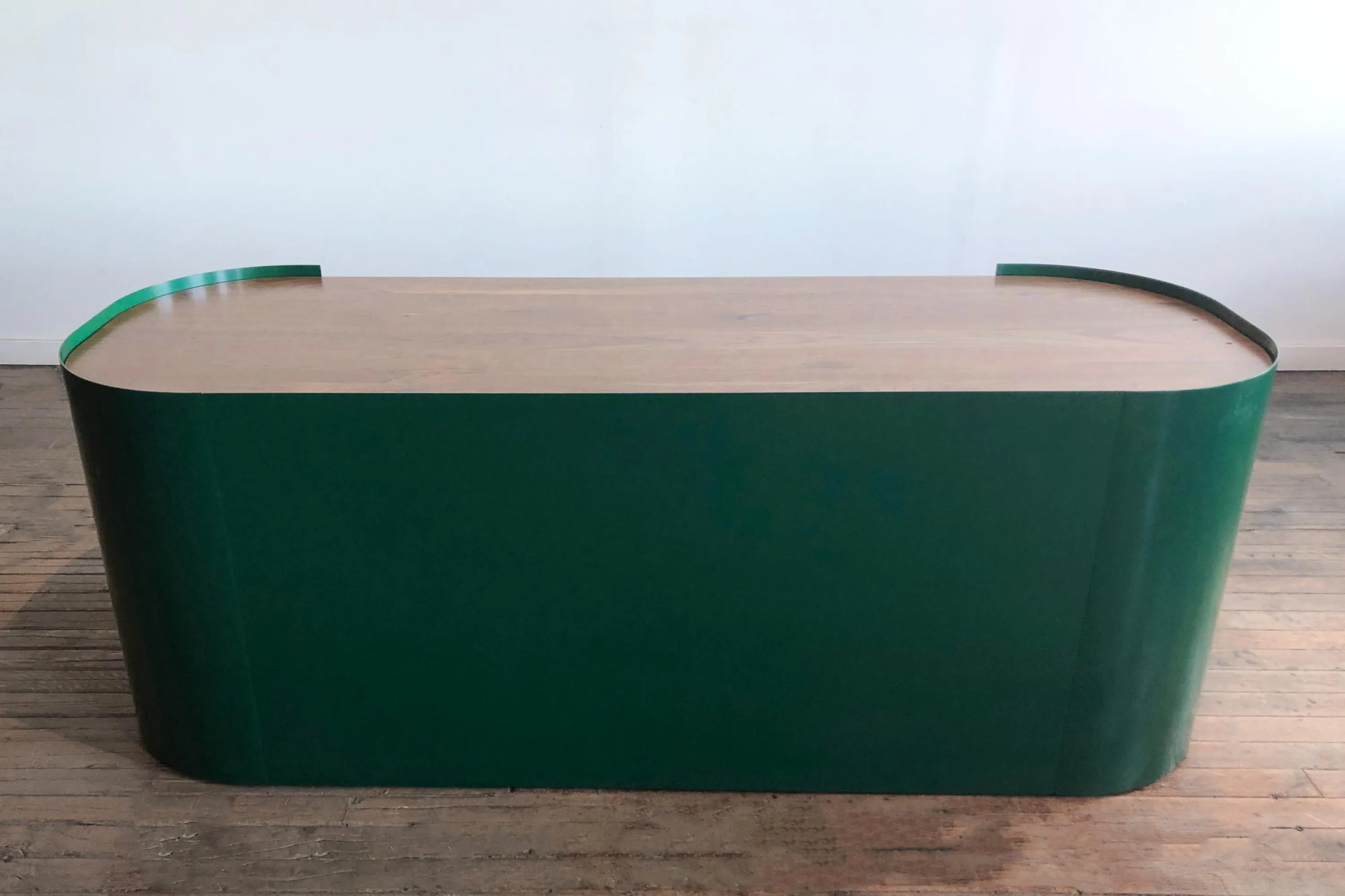 custom reception desk with powdercoated bent steel wrap and walnut top by Icon Modern