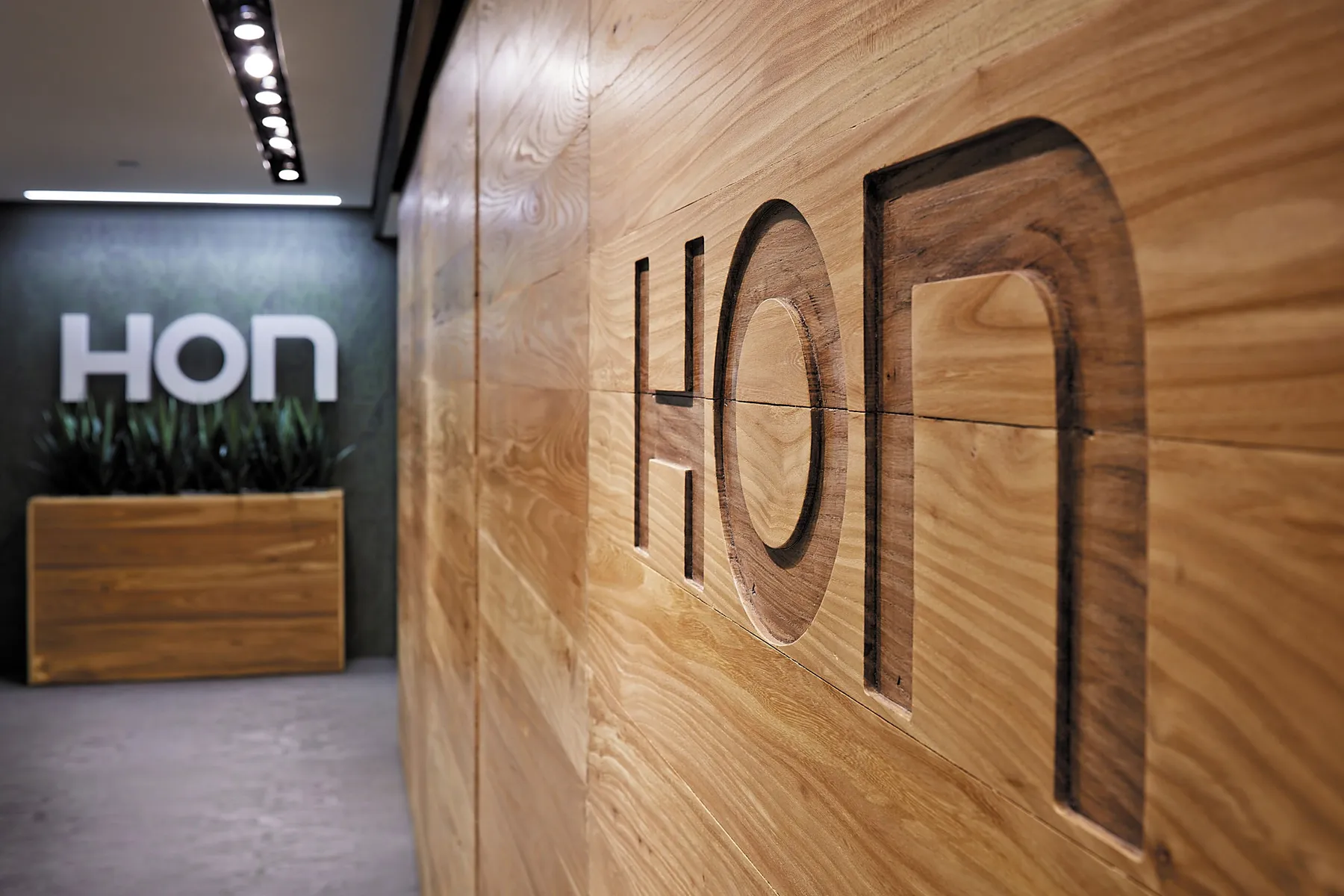 custom door in urban elm with CNC brand signage by Icon Modern