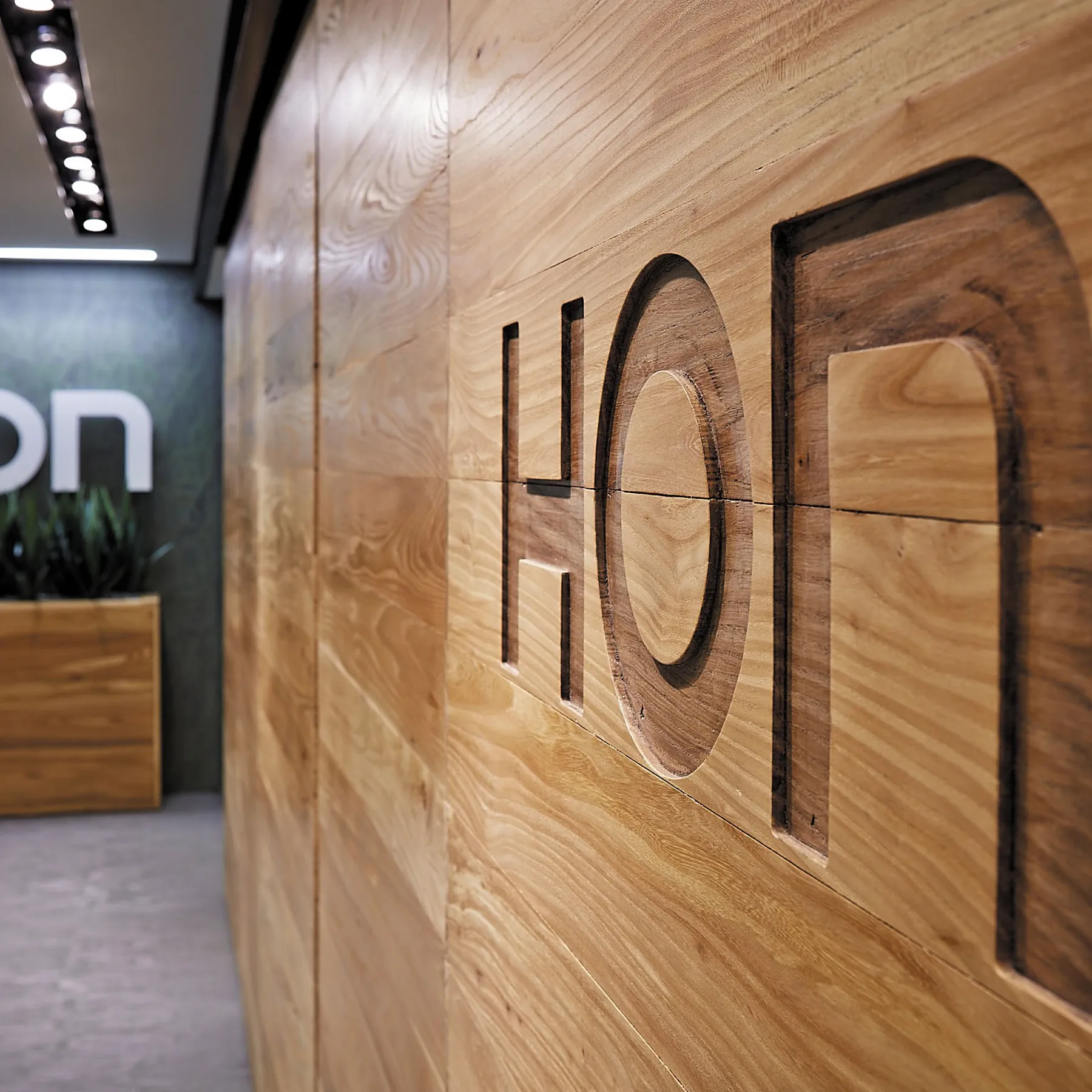 custom door in urban elm with CNC brand signage by Icon Modern
