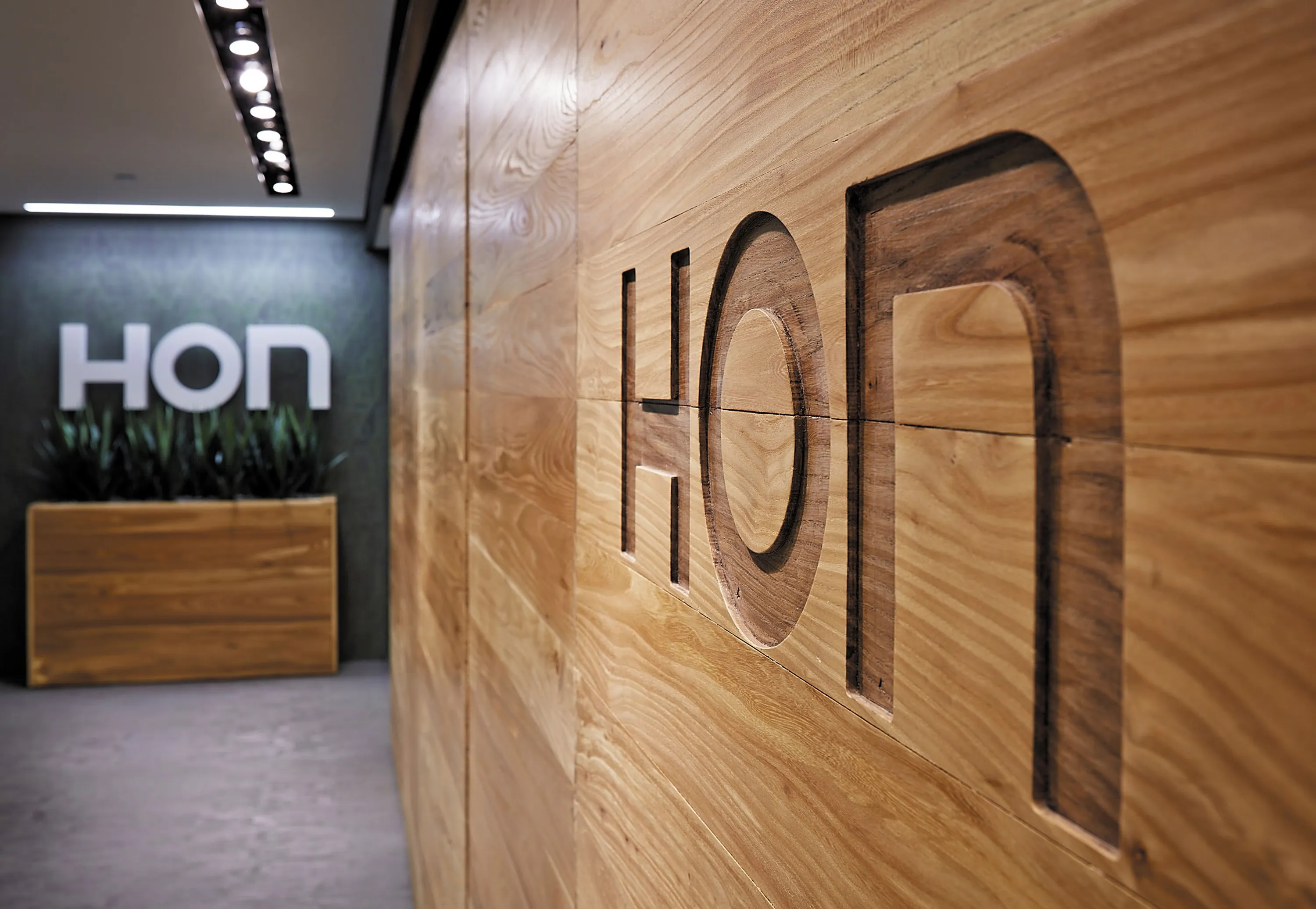 custom door in urban elm with CNC brand signage by Icon Modern