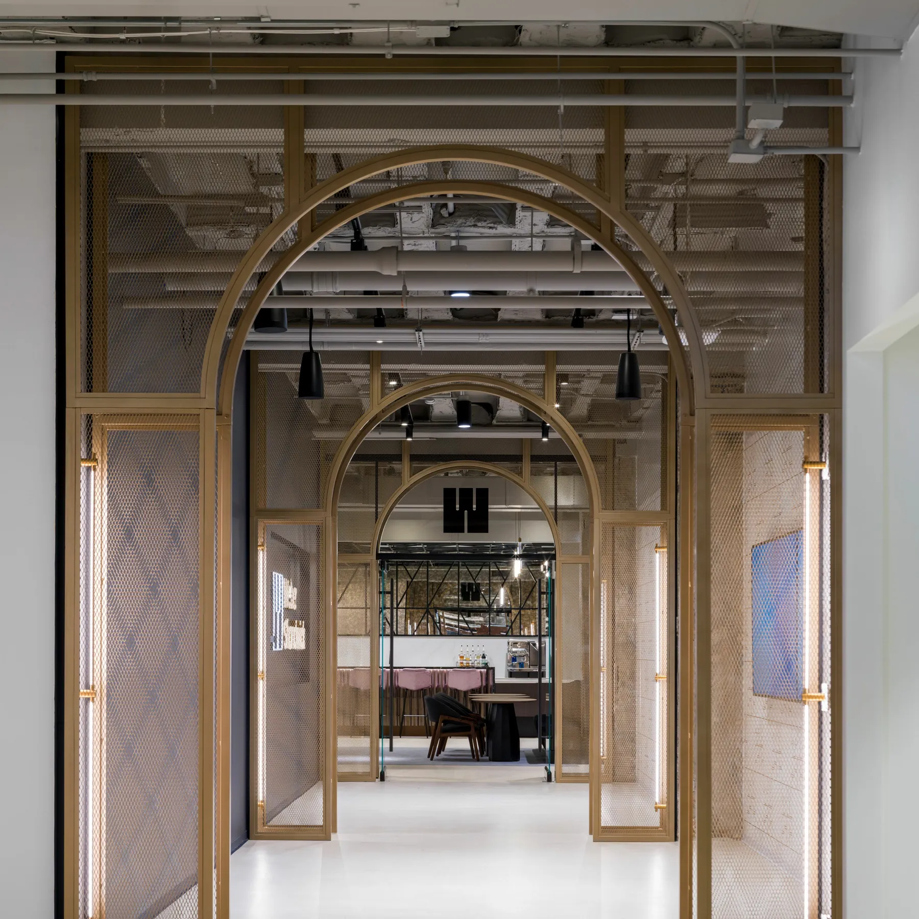 custom arched space dividers with steel tube and expanded metal infill, brass color powdercoat by Icon Modern