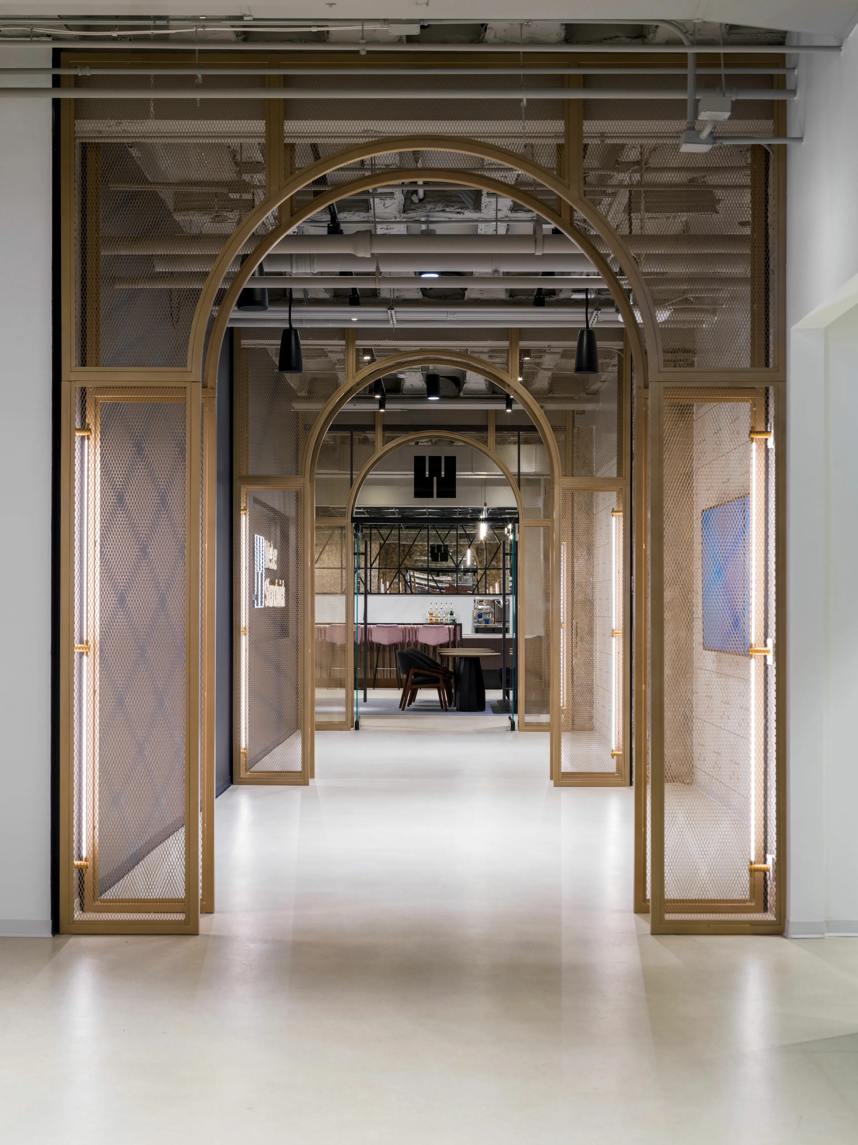 custom arched space dividers with steel tube and expanded metal infill, brass color powdercoat by Icon Modern