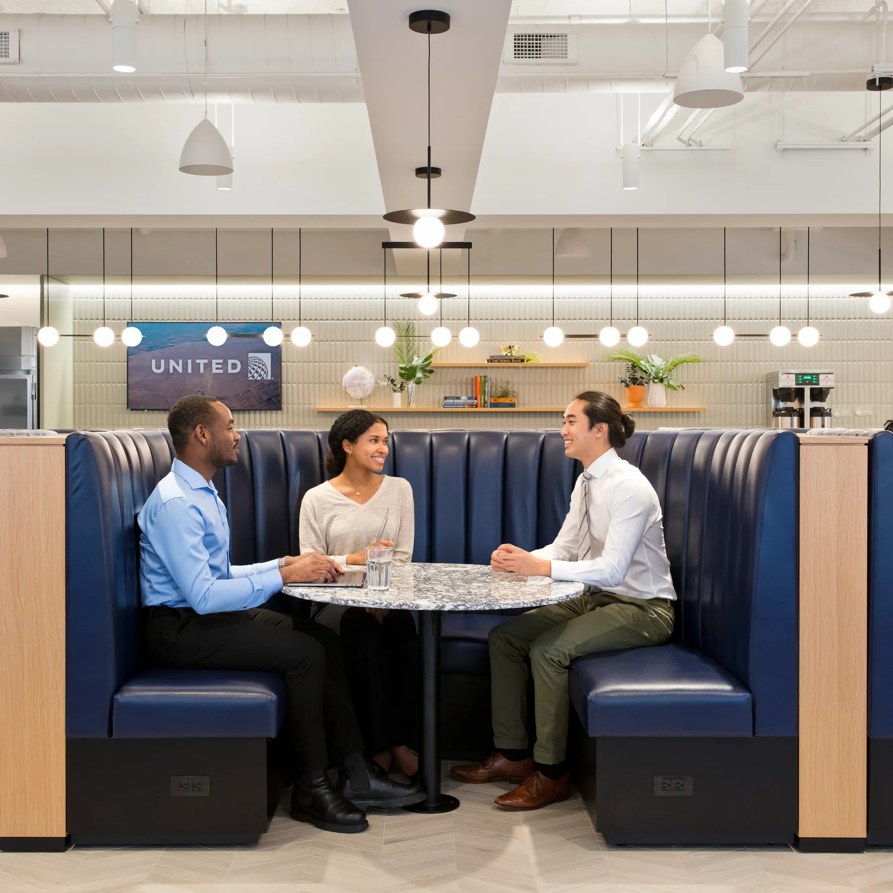custom stone cafe table and wood veneer banquette by Icon MOdern