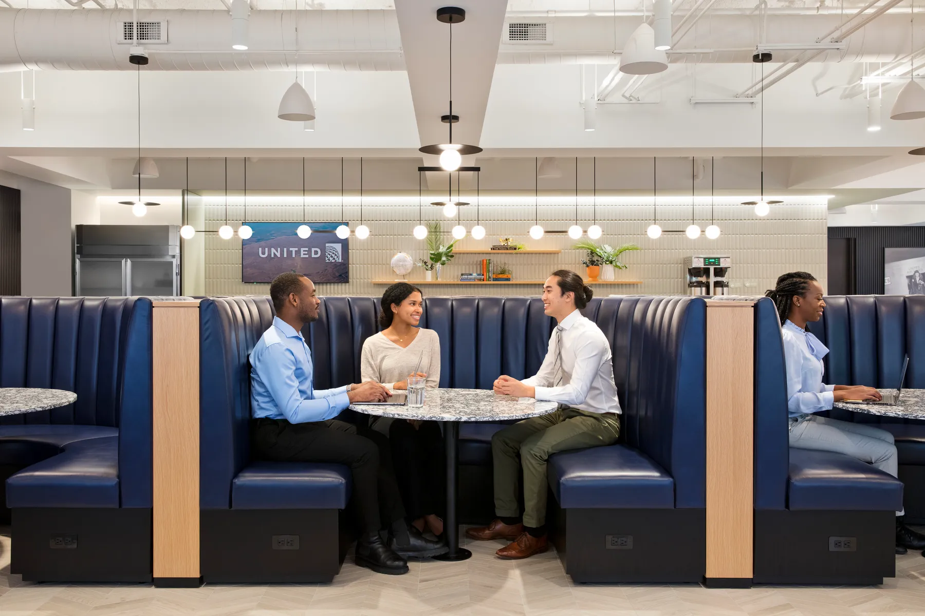 custom stone cafe table and wood veneer banquette by Icon MOdern