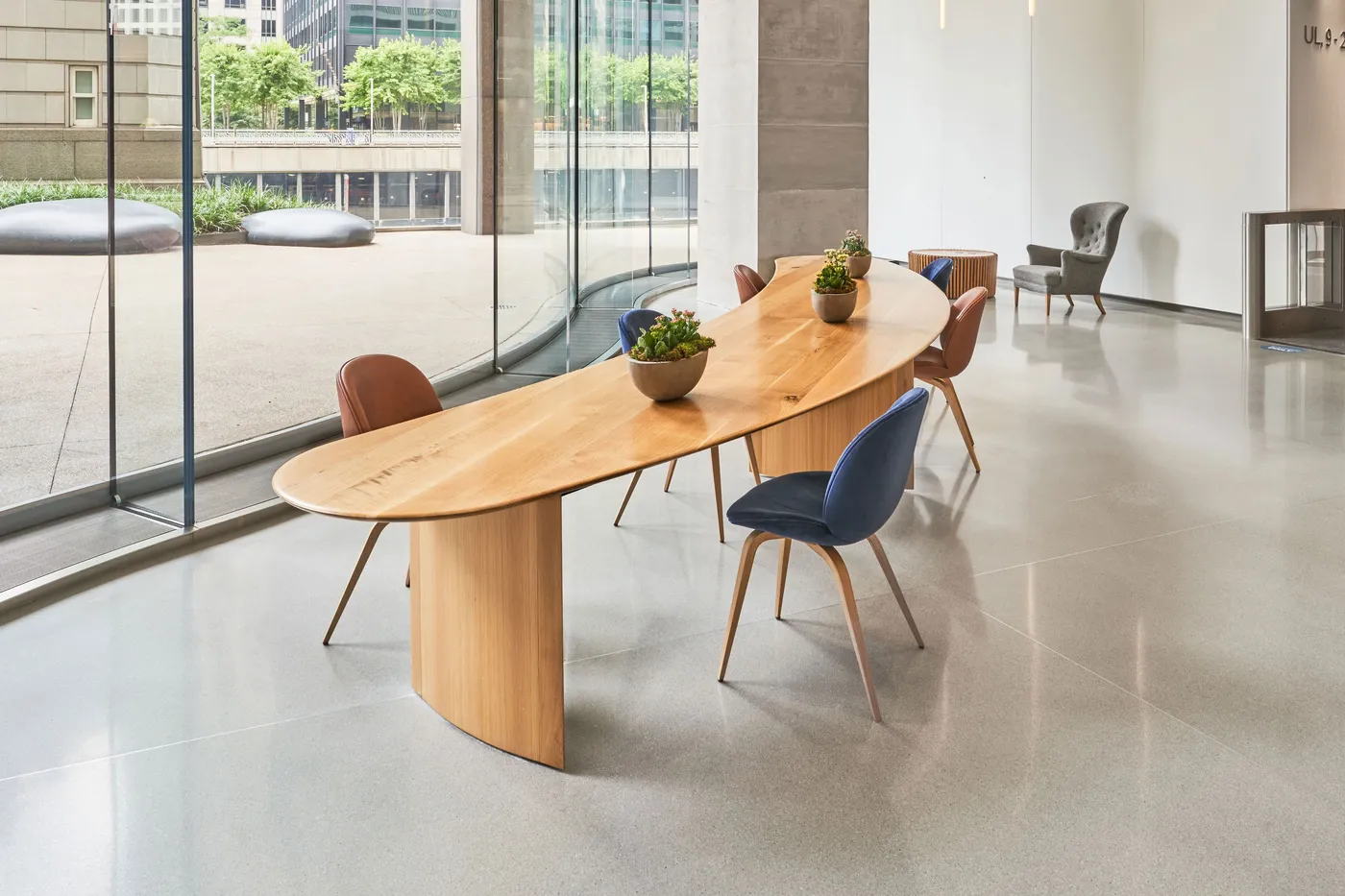 custom community table in urban oak in crescent shape by Icon Modern
