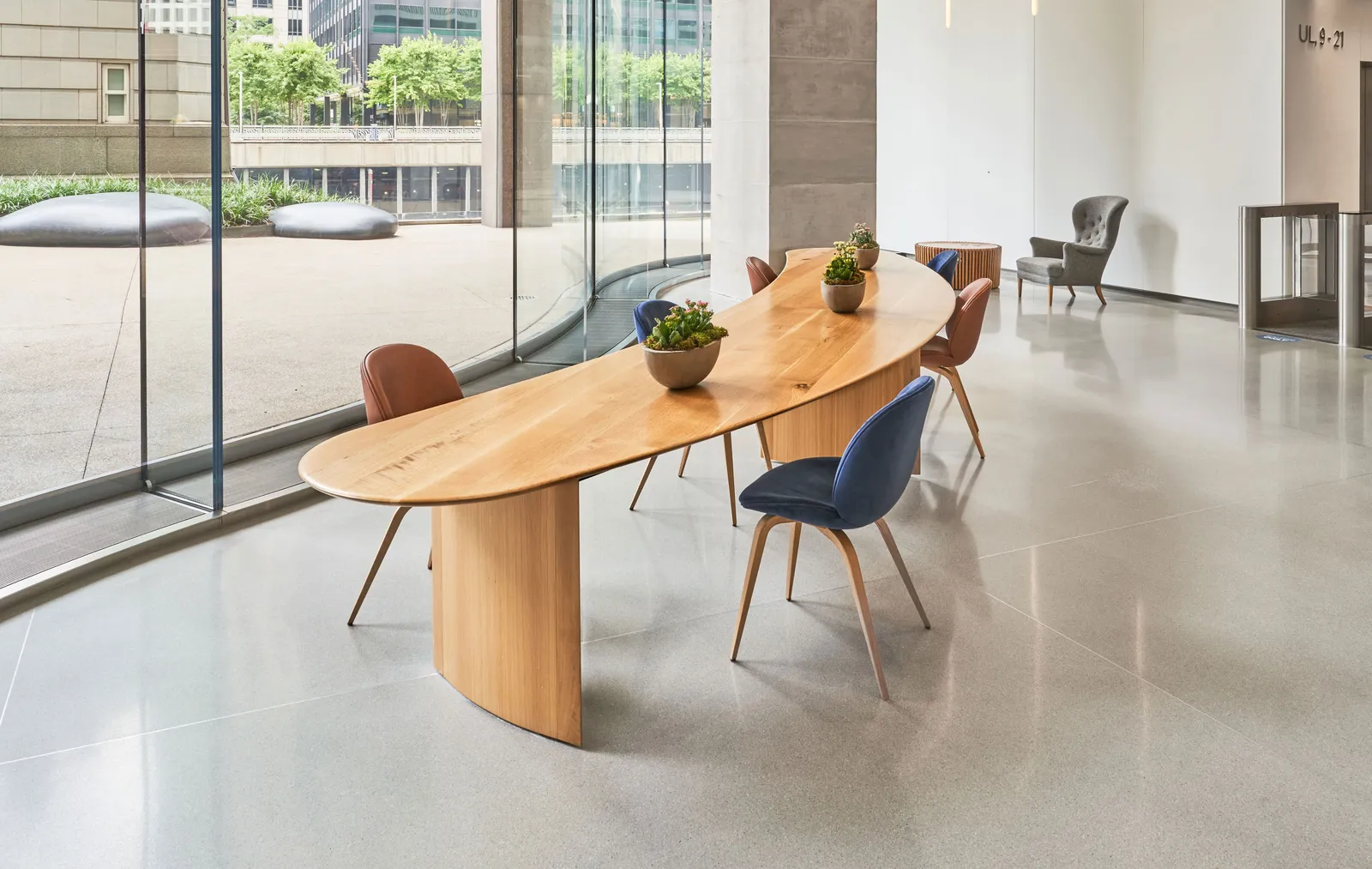 custom community table in urban oak in crescent shape by Icon Modern