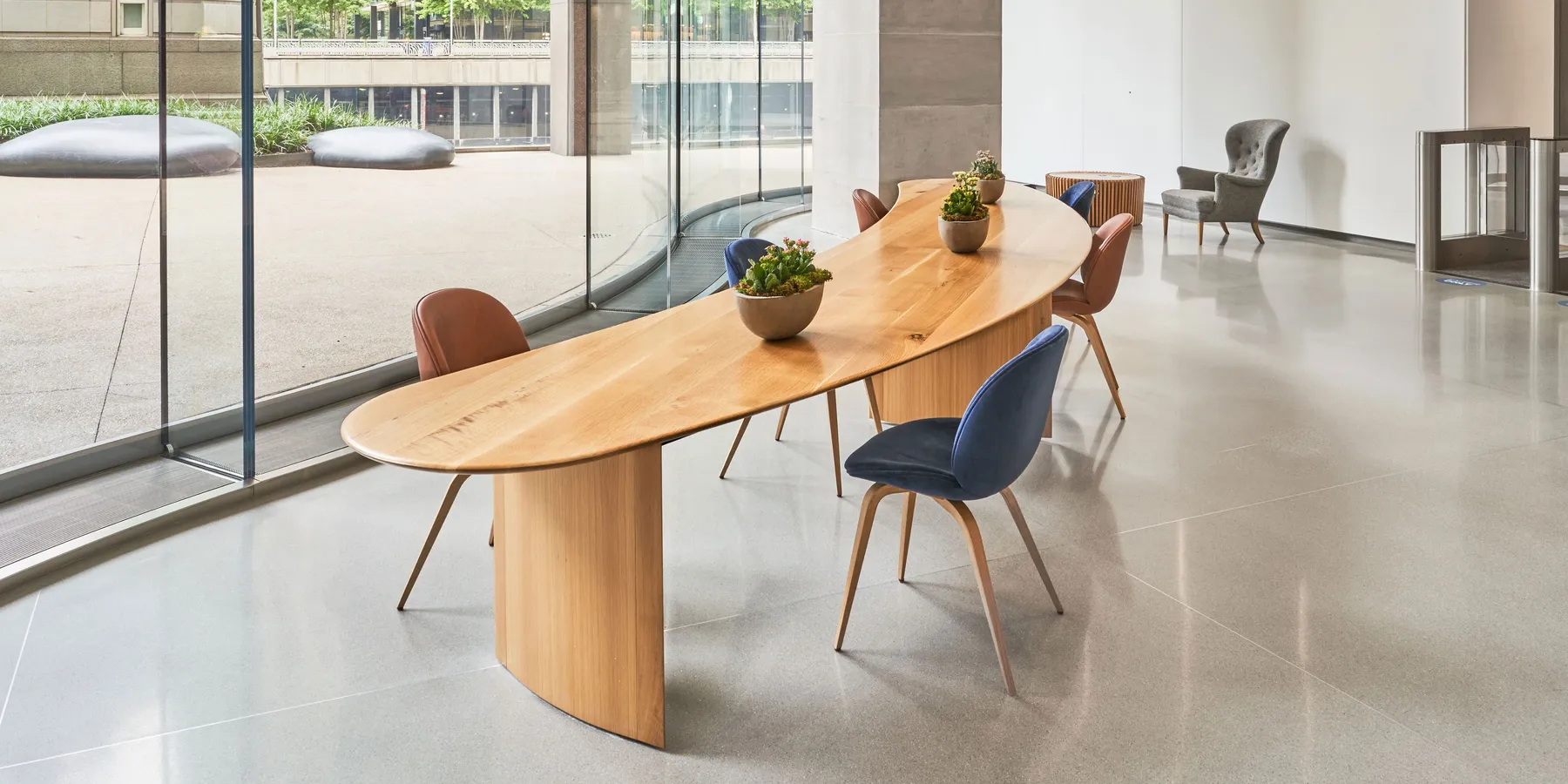 custom community table in urban oak in crescent shape by Icon Modern