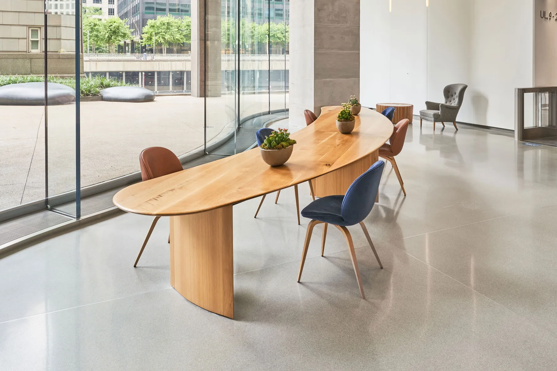 custom community table in urban oak in crescent shape by Icon Modern