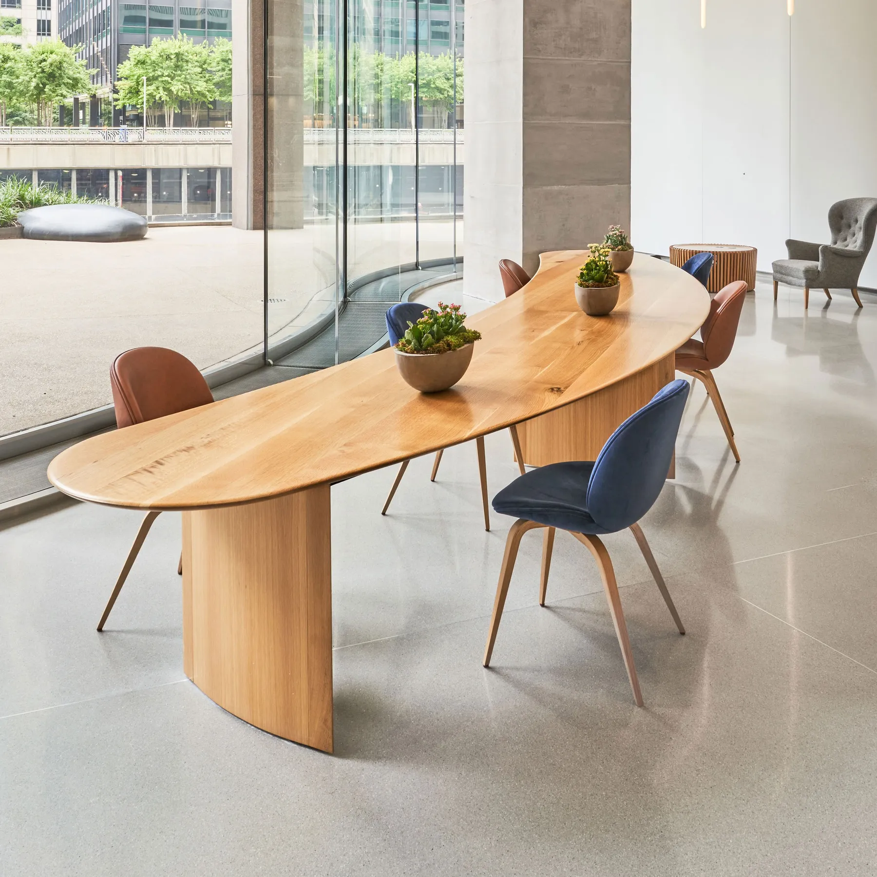 custom community table in urban oak in crescent shape by Icon Modern